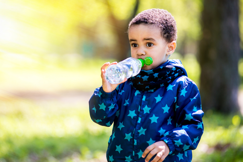 little boy drinking water from bottle