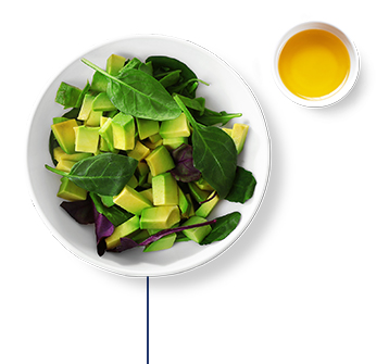 A mixed green salad with avocado, olive oil, and lime juice