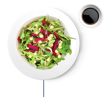 Salad with chickpeas, leafy greens, cucumbers, beets, & side dressing