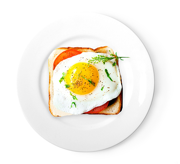 Breakfast sandwich with tomato and a sunny side up egg on top