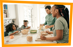 Family of four having breakfeast at kitchen table