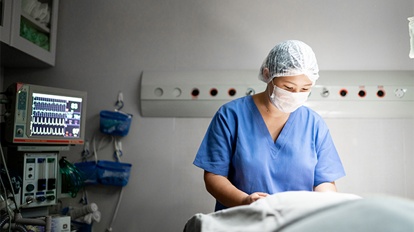 A healthcare professional provides care in the intensive care unit.