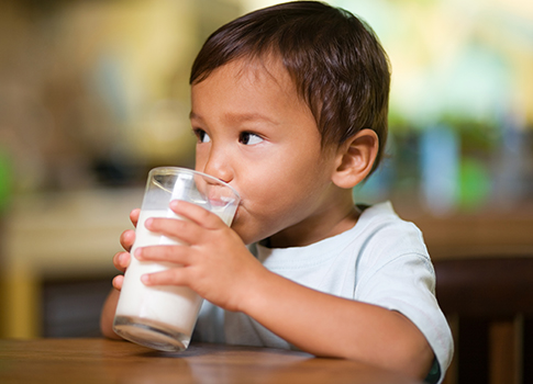 A young child with a glass of milk.