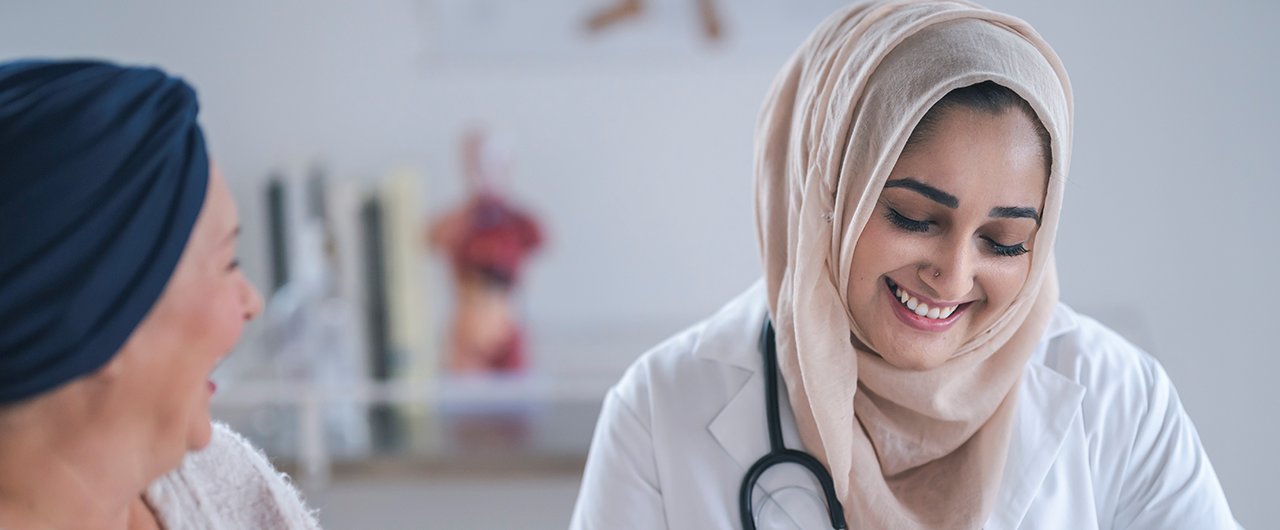 A Muslim doctor smiling with a female cancer patient