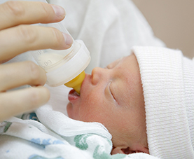 An infant getting bottle-fed