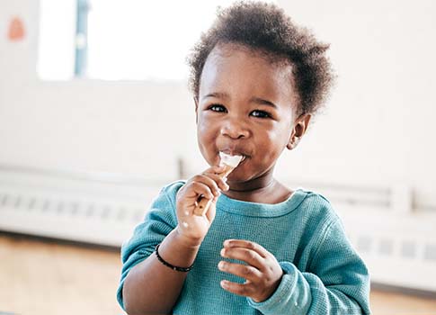 A toddler enjoys a food sampling.
