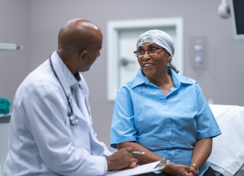 A lady with a head scarf talking to a medical professional.
