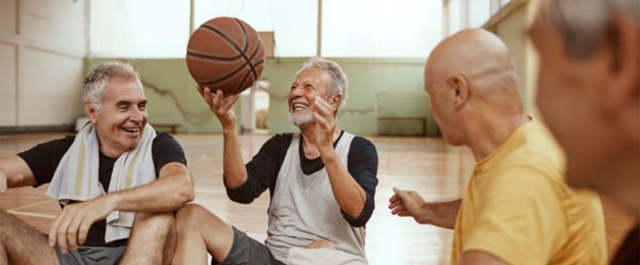 A group of aging men taking a break after playing basketball.