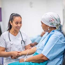 Infirmière tenant la main d’une patiente atteinte d’un cancer.