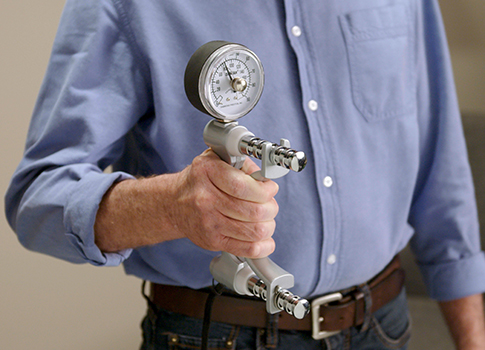 Medical professional holding a grip strength tool.