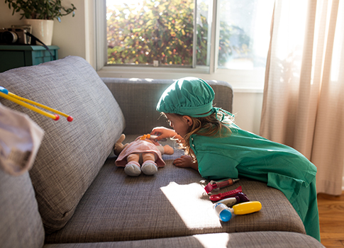 A child dressed in medical scrubs playing doctor.