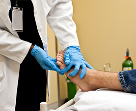A healthcare professional is checking a patient’s foot for foot ulcers.