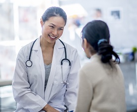 Smiling female physician consults with female patient