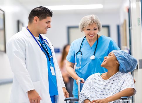 Healthcare professionals meet with a patient after surgery.