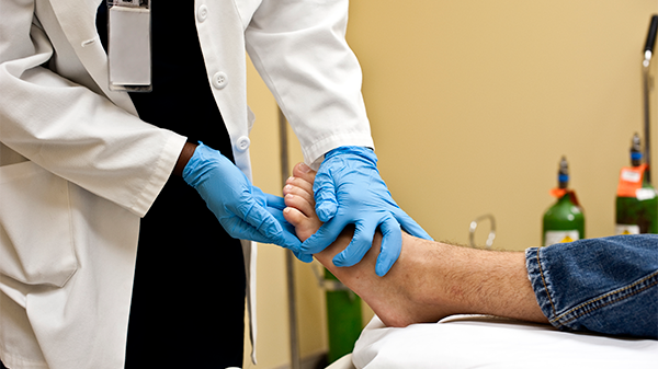 A healthcare professional is checking a patient’s foot for foot ulcers.