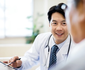 Young male physician uses iPad to share information with patient