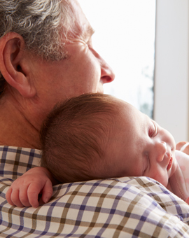 banner-grandfather-holding-sleeping-newborn-baby