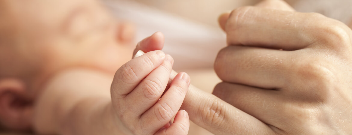 طفل يمسك إصبع أمه