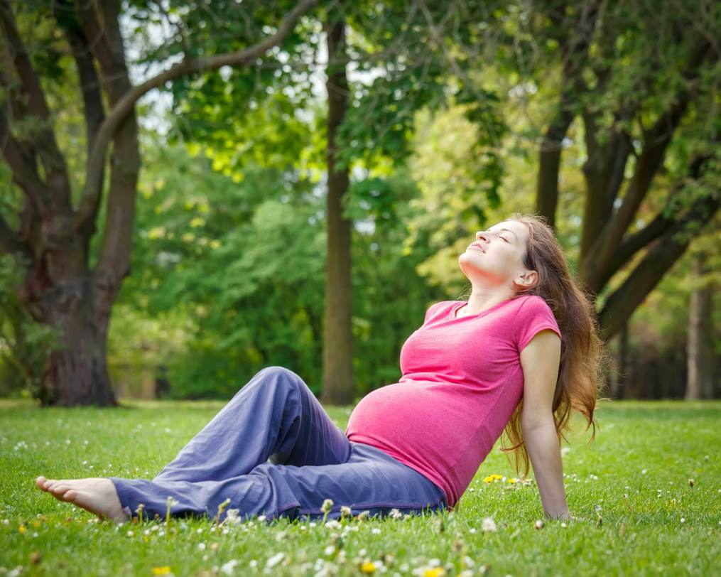 حامل تجلس على العشب لتستريح