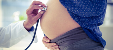 طبيب ينصت لنبضات قلب الجنين عبر سماعة يضعها على بطن الحامل
