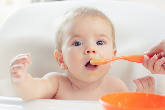 طفل يأكل طعامًا مهروسًا