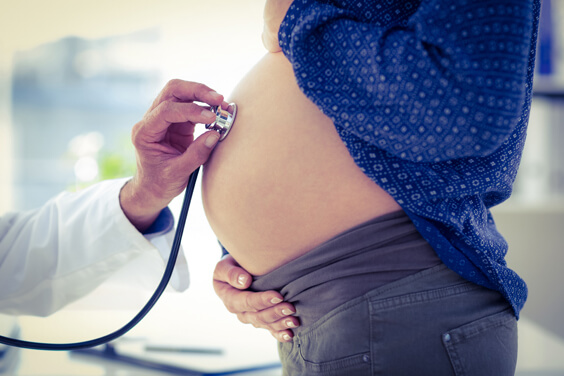 طبيب يفحص بطن امرأة حامل بواسطة سماعة