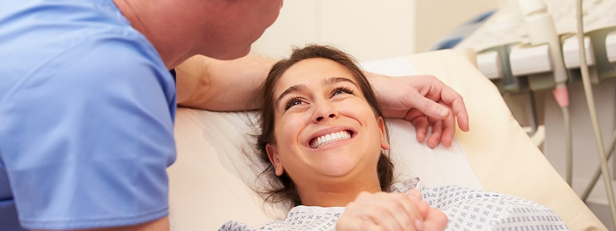 رجل يمسك بيد امرأة في غرفة الولادة