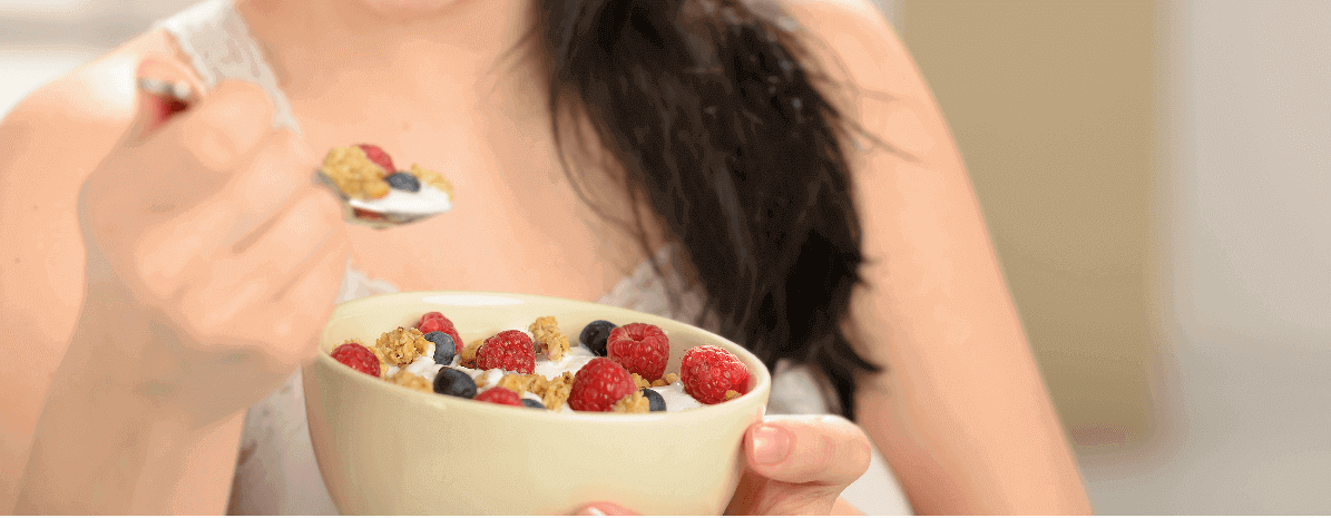 joyful-woman-eating-healthy-cereal-for-breakfasts