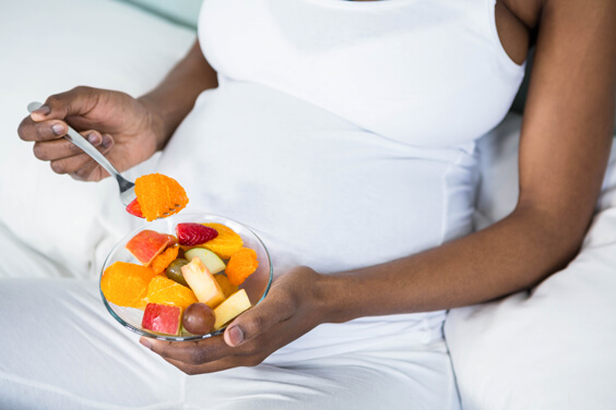 امرأة حامل تأكل سلطة الفواكه