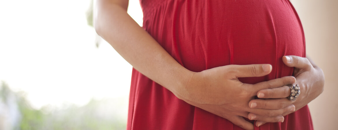 امرأة حامل تضع يديها على بطنها