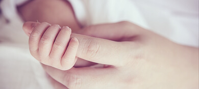 يد امرأة تمسك بيد طفلها