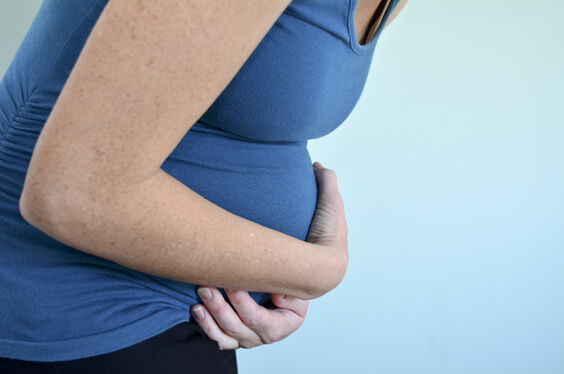 امرأة حامل تمسك بطنها من الألم