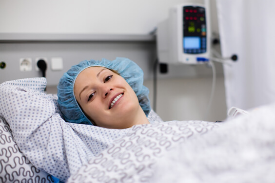 امرأة شابة مستلقية مع قبعة الجراحة