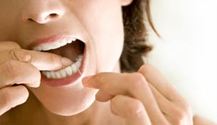 A woman flossing her teeth