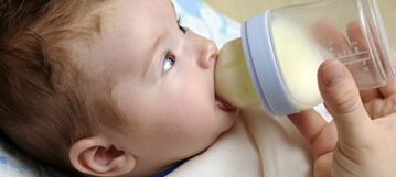 תינוק שותה מבקבוק חלב