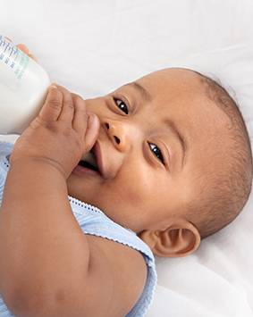 baby-holding-milk-bottle-lying-down