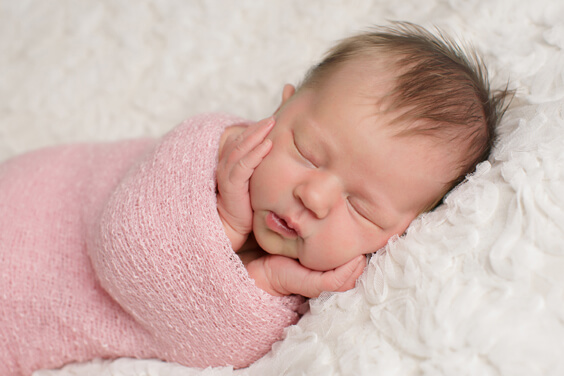 תינוקת עטופה בשמיכה ורודה ישנה