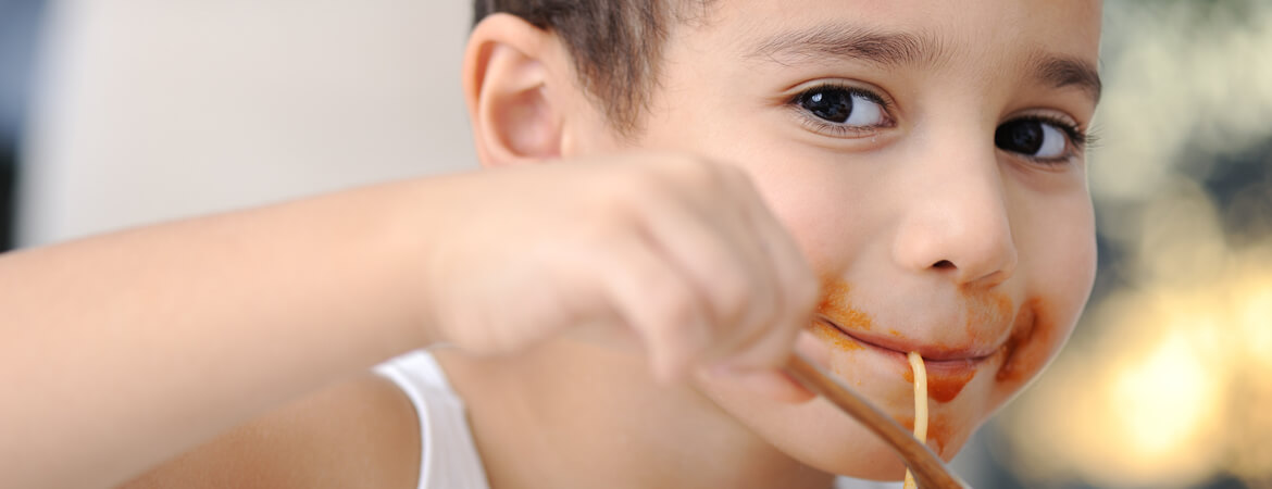 ילד אוכל פסטה ברוטב עגבניות