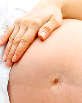 אישה בהריון שוכבת על הצד ומחזיקה את הבטןן