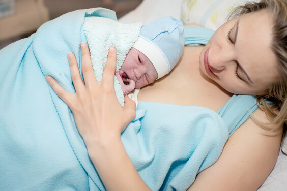 אישה עם תינוק שזה עתה נולד מונח עליה