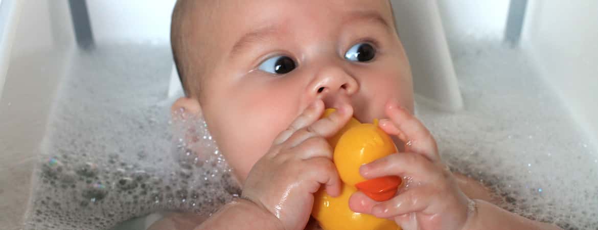 תינוק באמבטיה מכניס ברווז לפה