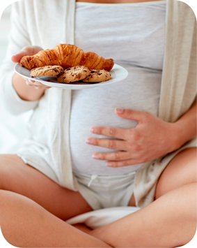 אישה בהריון מחזיקה צלחת עם עוגיות