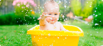 תינוק עושה אמבטיה בדשא