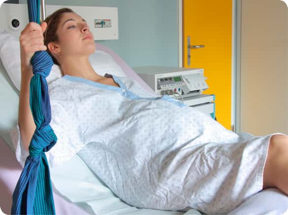 אישה הריונית שוכבת במיטה בבית החולים