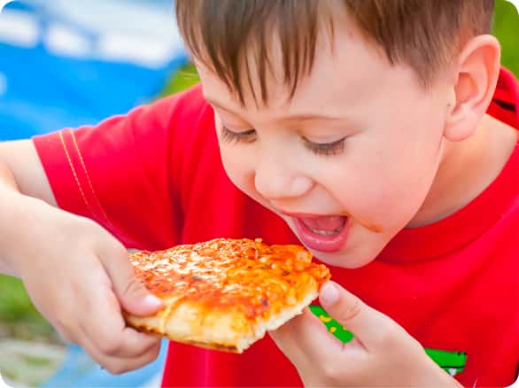 ילד אוכל משולש פיצה