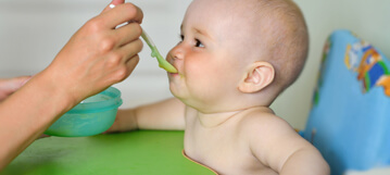 תינוק אוכל עם כפית