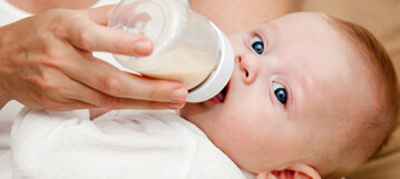 תינוק שותה בקבוק חלב