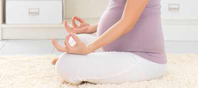 אישה בהריון עושה יוגה ומדיטציה